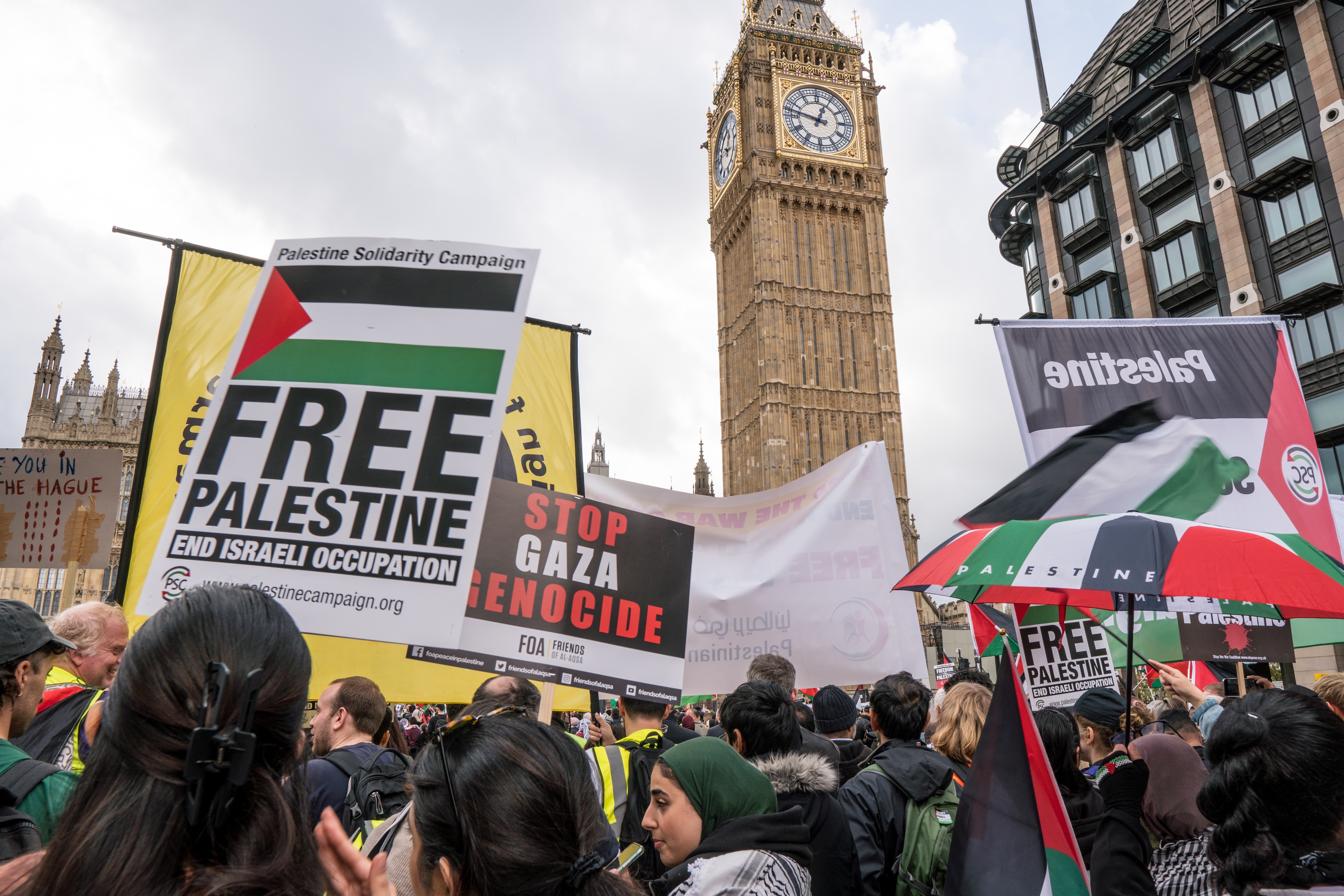 Un hombre escala la torre del Big Ben ondeando una bandera palestina